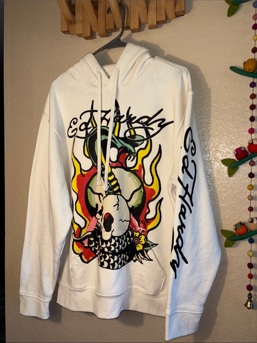 NWOT Ed Hardy cream colored hoodie features a graphic of a burning skull and sna